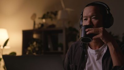 فردی در حال نوشیدن قهوه با هدفون، تمرکز عمیق و هم‌افزایی دوپامین